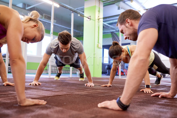 group of people doing straight arm plank in gym Stock photo © dolgachov