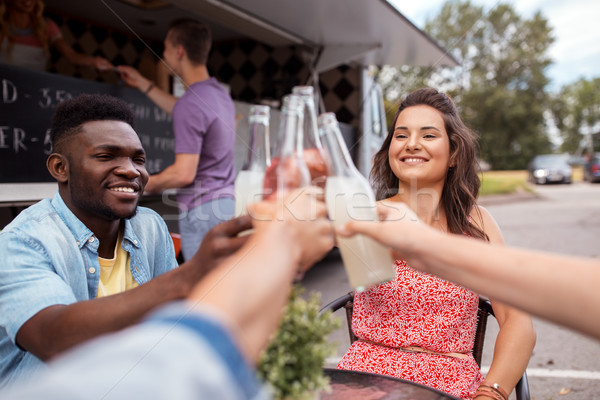 friends clinking bottles with drinks at food truck Stock photo © dolgachov