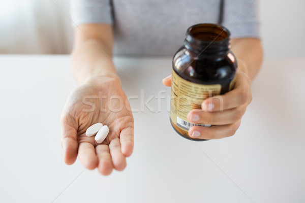 close up of hands holding medicine pills and jar Stock photo © dolgachov