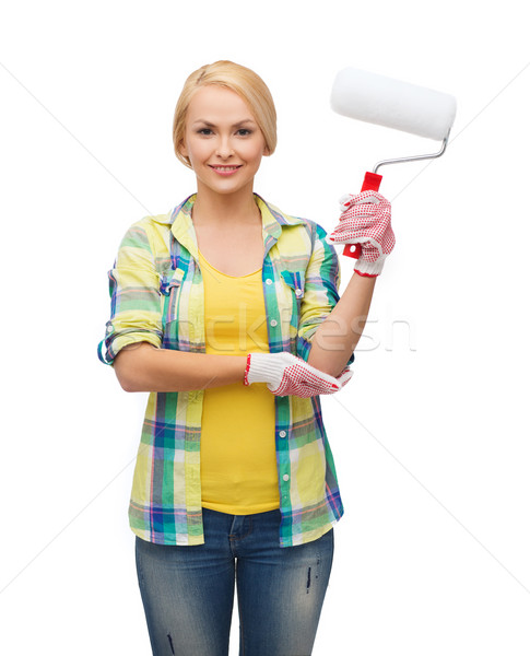 smiling woman in gloves with paint roller Stock photo © dolgachov