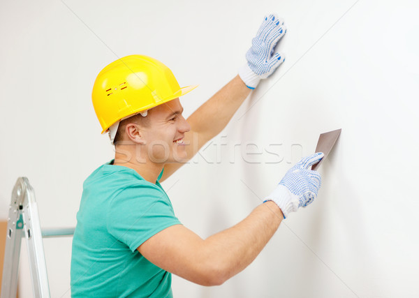 smiling man in helmet doing renovations at home Stock photo © dolgachov