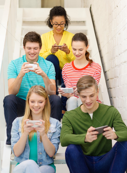 Mosolyog diákok okostelefon sms chat iskola oktatás Stock fotó © dolgachov