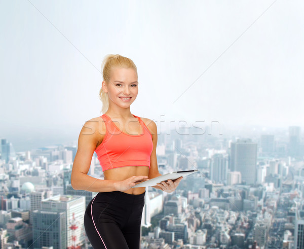 smiling sporty woman with tablet pc computer Stock photo © dolgachov