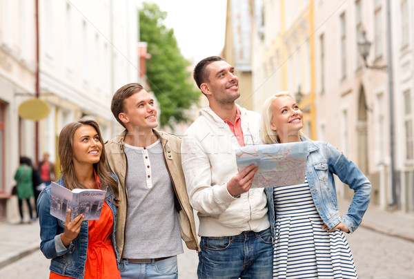 group of smiling friends with city guide and map Stock photo © dolgachov