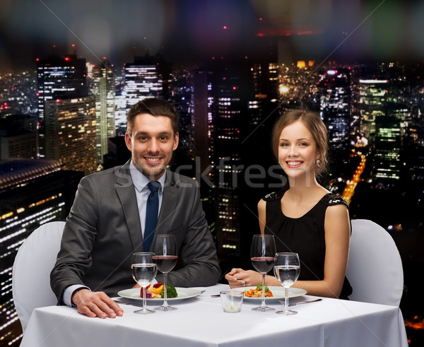 smiling couple eating main course at restaurant Stock photo © dolgachov