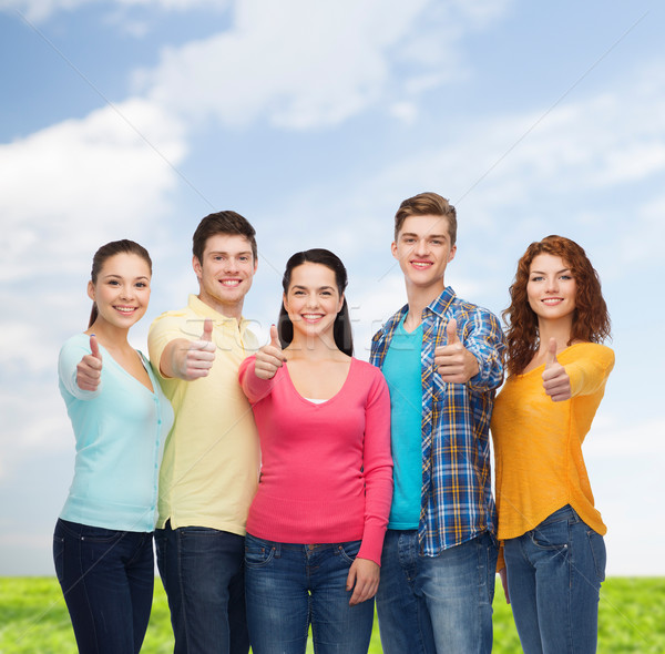 Groupe souriant adolescents ciel bleu herbe amitié [[stock_photo]] © dolgachov