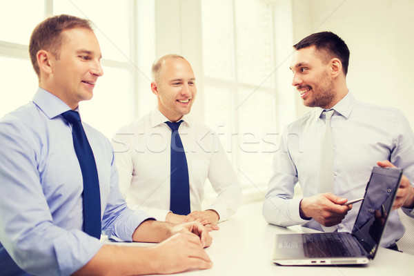 Stock photo: smiling businessmen having discussion in office