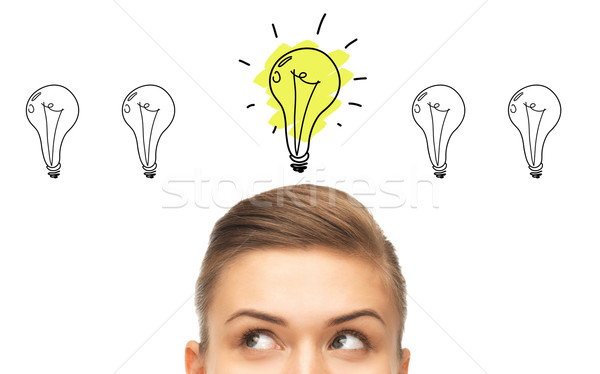 close up of woman looking to lighting bulbs Stock photo © dolgachov