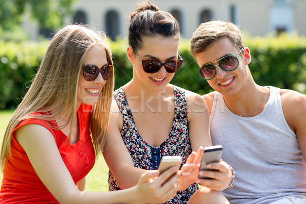 Stockfoto: Glimlachend · vrienden · smartphones · vergadering · park · vriendschap