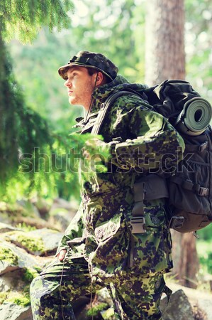 close up of soldier or hunter with gun in forest Stock photo © dolgachov
