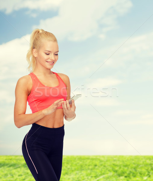 smiling sporty woman with smartphone Stock photo © dolgachov