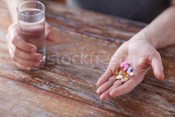 close up of male hands holding pills and water Stock photo © dolgachov