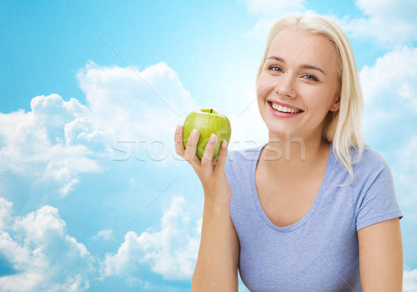 happy woman eating green apple over sky Stock photo © dolgachov
