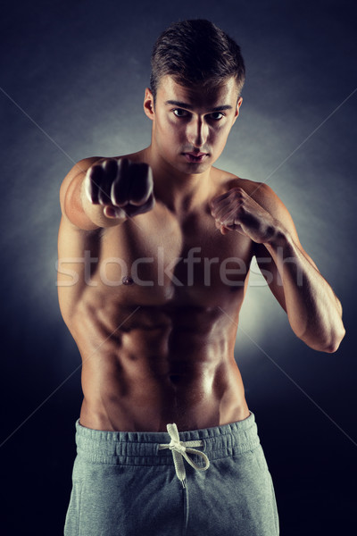 young man on fighting stand over black background Stock photo © dolgachov