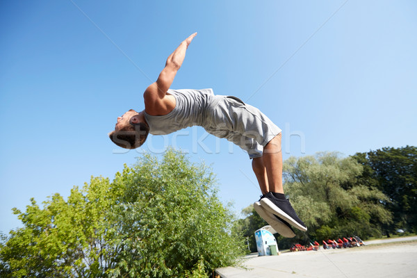 sporty young man jumping in summer park Stock photo © dolgachov