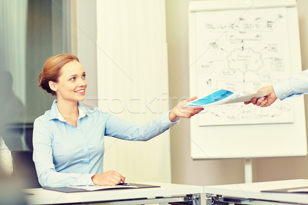businesswoman taking papers from someone in office Stock photo © dolgachov