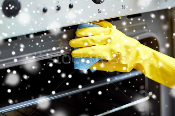 Stock photo: close up of woman cleaning oven at home kitchen