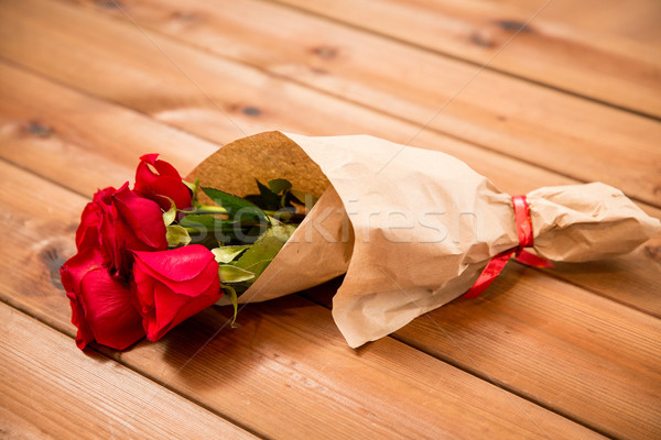 close up of red roses bunch wrapped into paper Stock photo © dolgachov