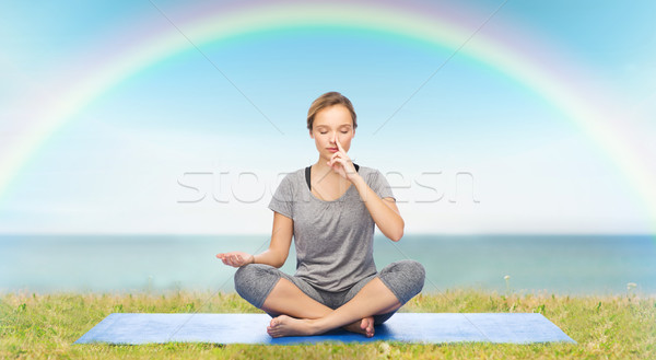 woman making yoga meditation in lotus pose on mat Stock photo © dolgachov