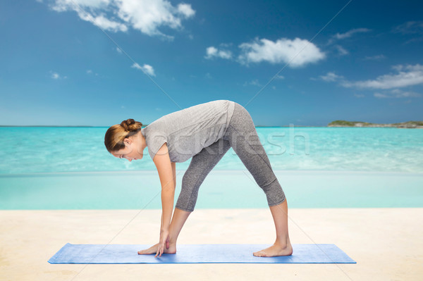 woman making yoga intense stretch pose on mat Stock photo © dolgachov