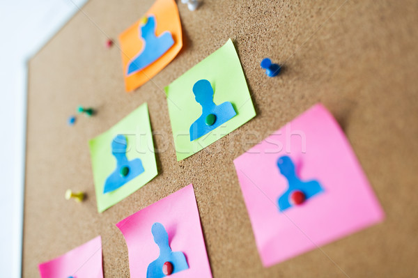 close up of paper human shapes on cork board Stock photo © dolgachov