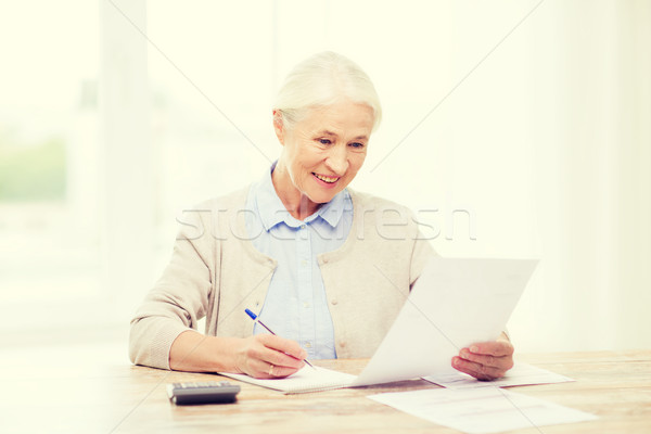 senior woman with papers and calculator at home Stock photo © dolgachov