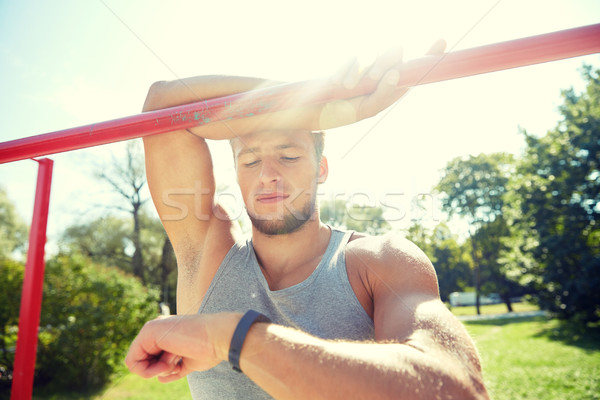 man with heart-rate watch exercising outdoors Stock photo © dolgachov