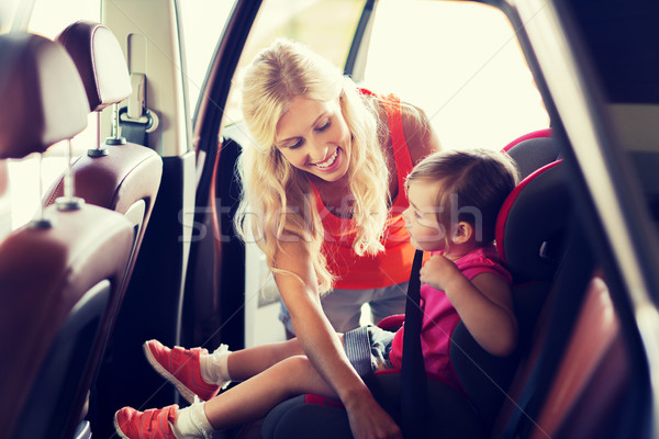 happy mother fastening child with car seat belt Stock photo © dolgachov