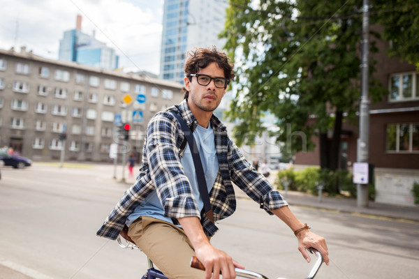 young hipster man with bag riding fixed gear bike Stock photo © dolgachov