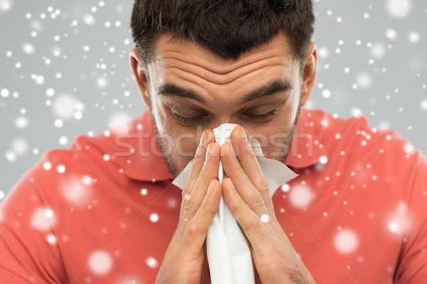 sick man with paper wipe blowing nose over snow Stock photo © dolgachov