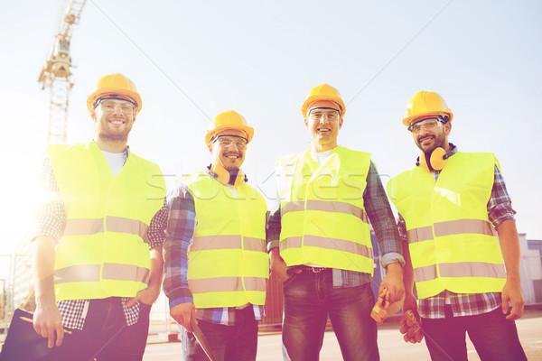group of smiling builders with tablet pc outdoors Stock photo © dolgachov