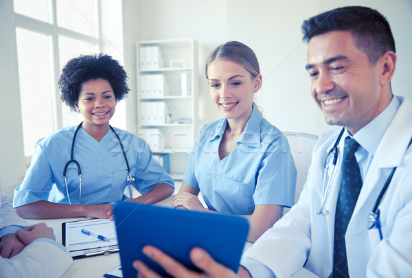 happy doctors with tablet pc meeting at hospital Stock photo © dolgachov