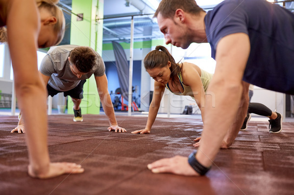 group of people doing straight arm plank in gym Stock photo © dolgachov