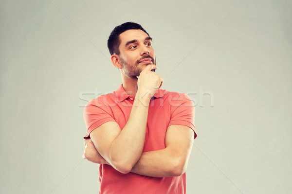 man in polo t-shirt thinking over gray background Stock photo © dolgachov