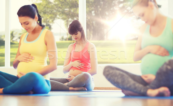 happy pregnant women exercising yoga in gym Stock photo © dolgachov