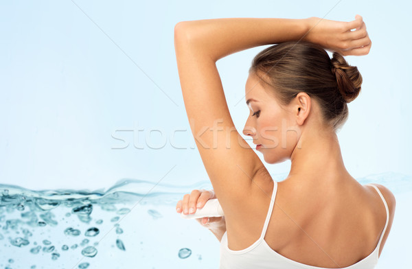 woman with antiperspirant deodorant over blue Stock photo © dolgachov