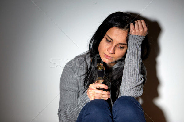 unhappy drunk crying woman with bottle of alcohol Stock photo © dolgachov