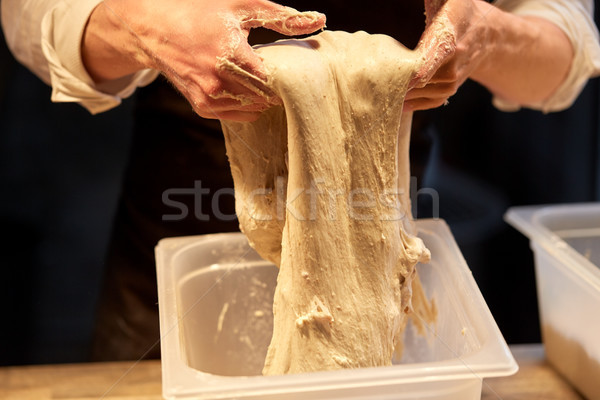 close up of baker hands making bread dough Stock photo © dolgachov