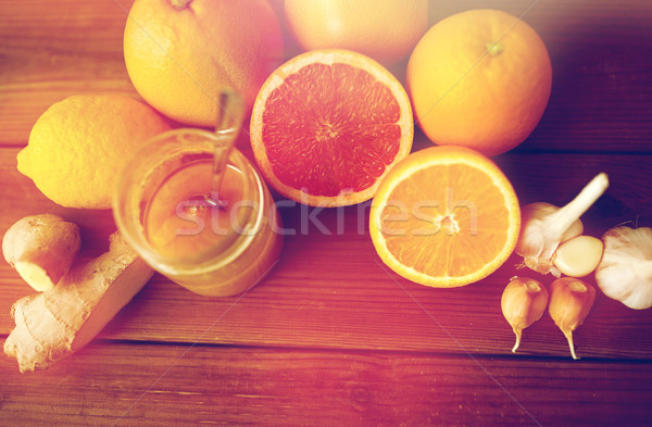 honey, citrus fruits, ginger and garlic on wood Stock photo © dolgachov