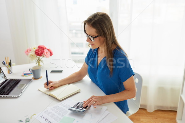 woman with calculator and notebook at office Stock photo © dolgachov