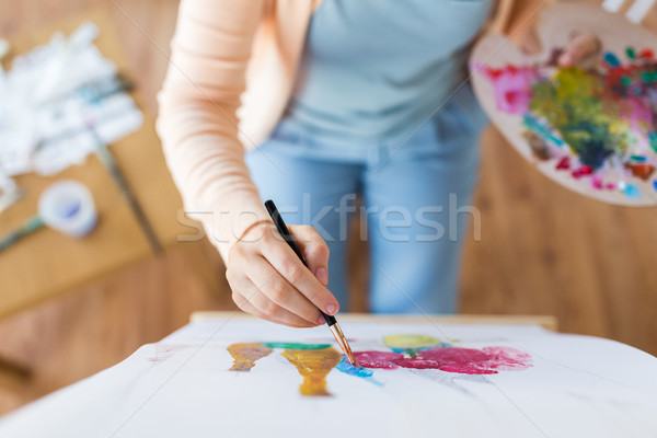 artist with palette and brush painting at studio Stock photo © dolgachov