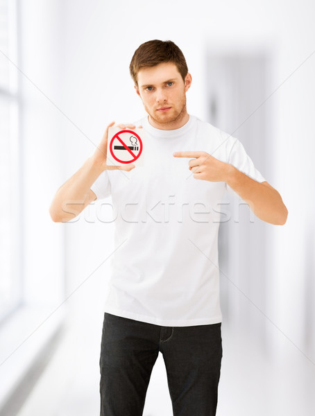 young man pointing at no smoking sign Stock photo © dolgachov