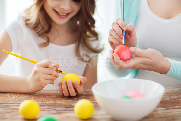close up of little girl and mother coloring eggs Stock photo © dolgachov