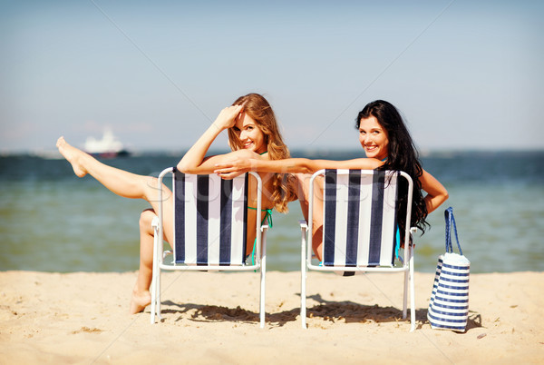 girls sunbathing on the beach chairs Stock photo © dolgachov