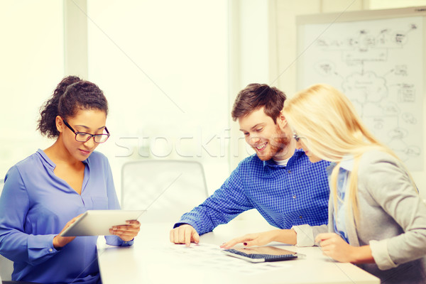 Stock photo: smiling team with table pc and papers working