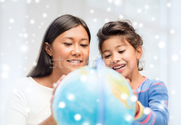 mother and daughter with globe indoors Stock photo © dolgachov