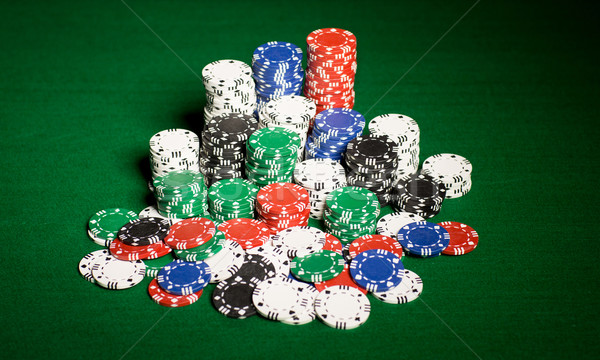 Stock photo: close up of casino chips on green table surface