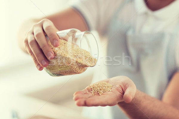 close up of male emptying jar with quinoa Stock photo © dolgachov