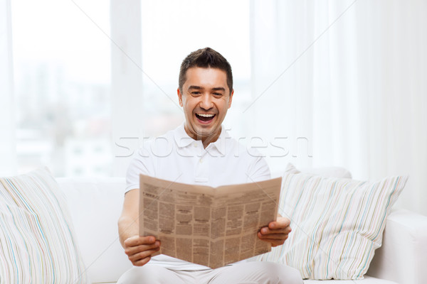 happy man reading newspaper and laughing at home Stock photo © dolgachov