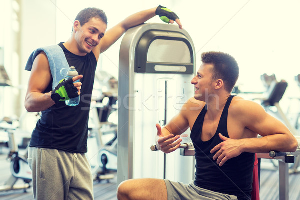 smiling men exercising on gym machine Stock photo © dolgachov